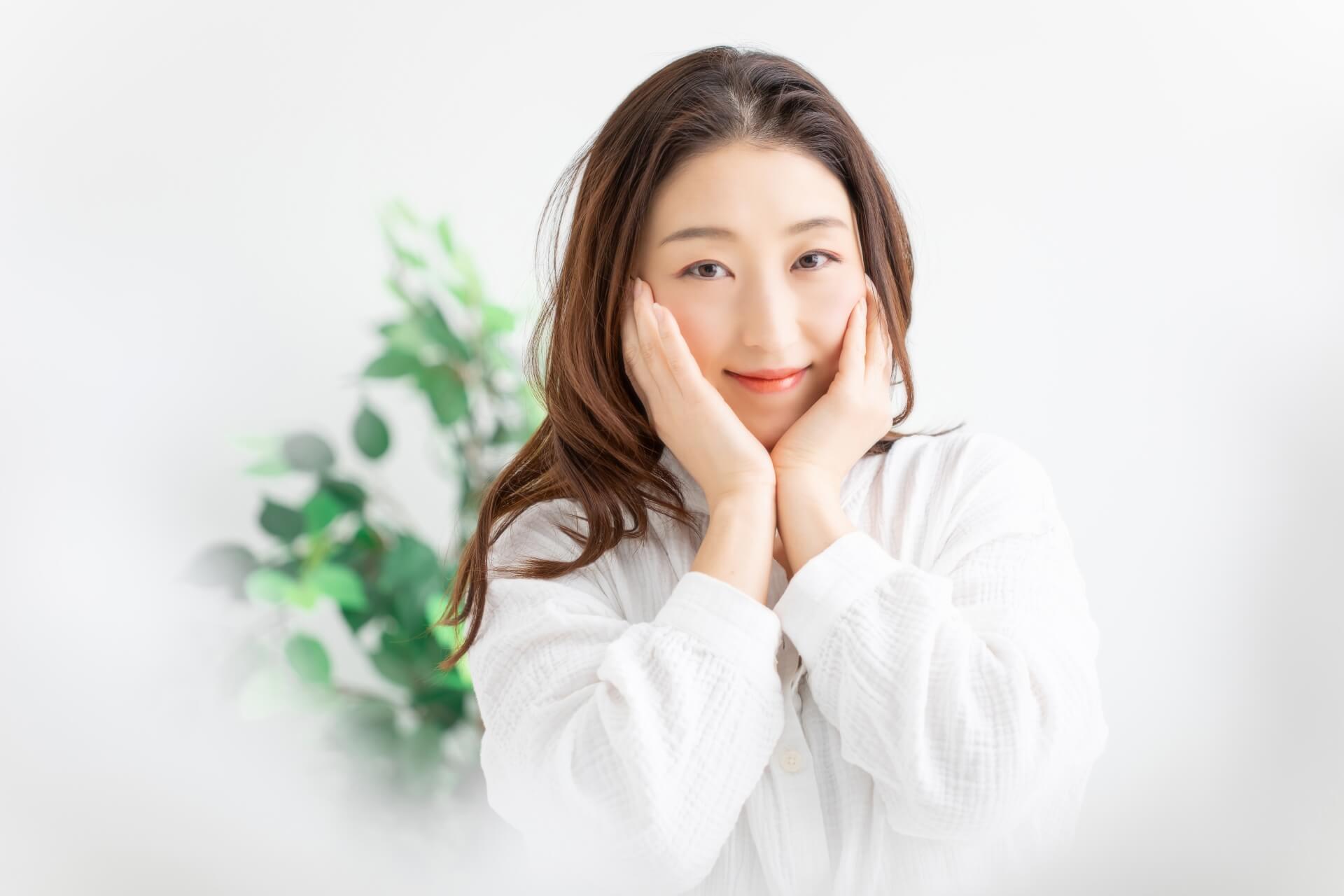 ほほを両手で支える微笑む女性