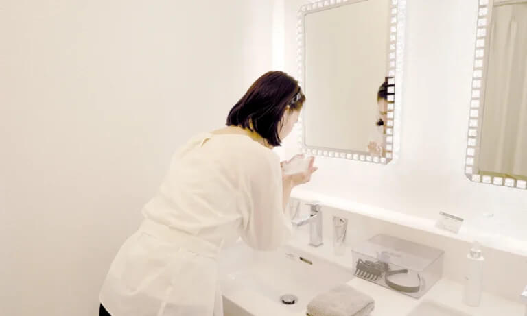 洗面台でスキンケアをする女性